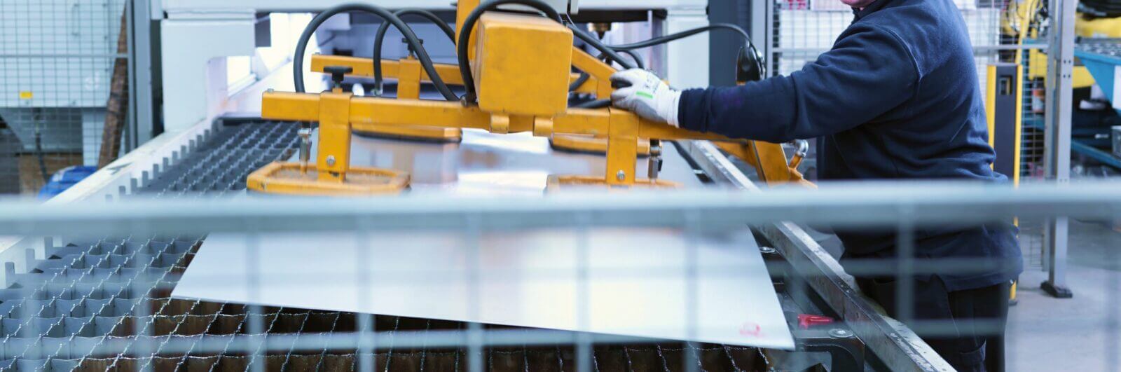 Worker loading sheet metal into a machine