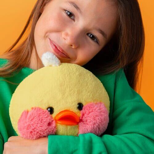 Pre-teen girl hugging a plush duck toy