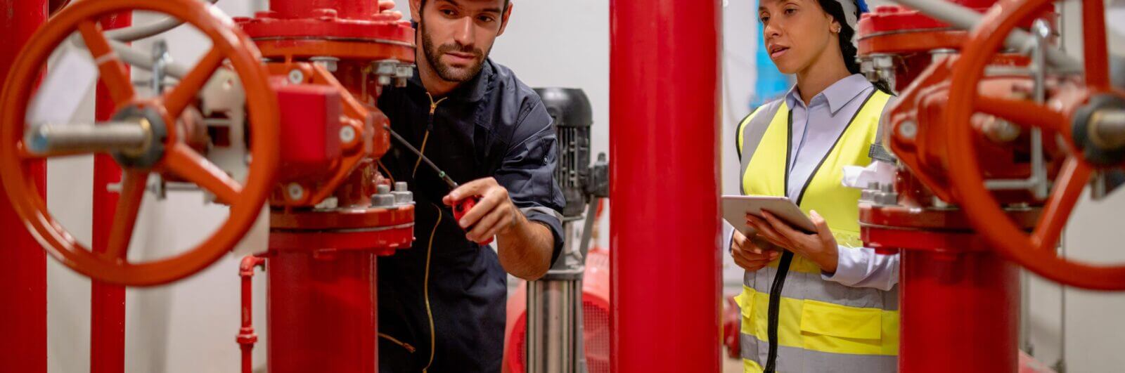 Worker inspecting industrial fire suppression equipment