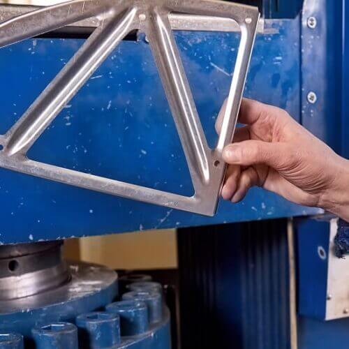 Worker inspects a stamped metal part