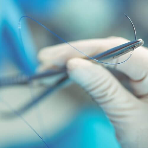 Surgeon holding small medical instruments