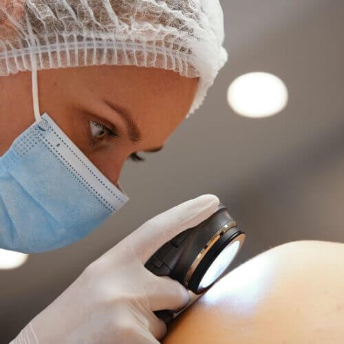 A dermatologist examines a patient's skin