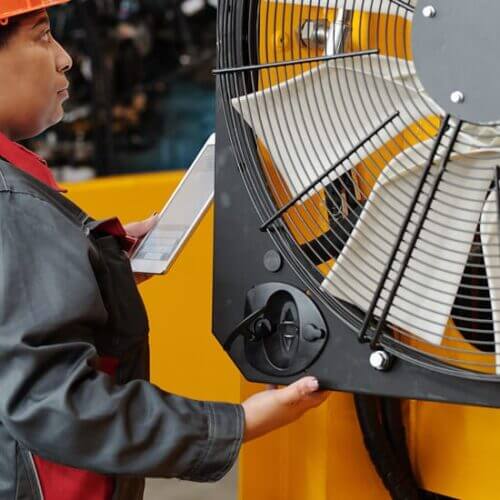 Worker inspects a large industrial fan