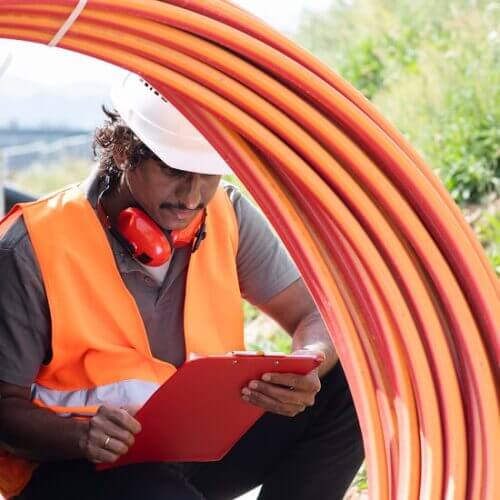 Worker installing underground telecommunications cable