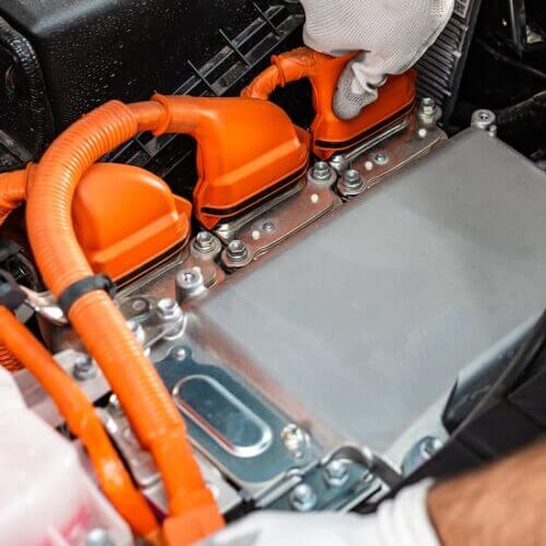 Factory worker plugging in an automotive battery