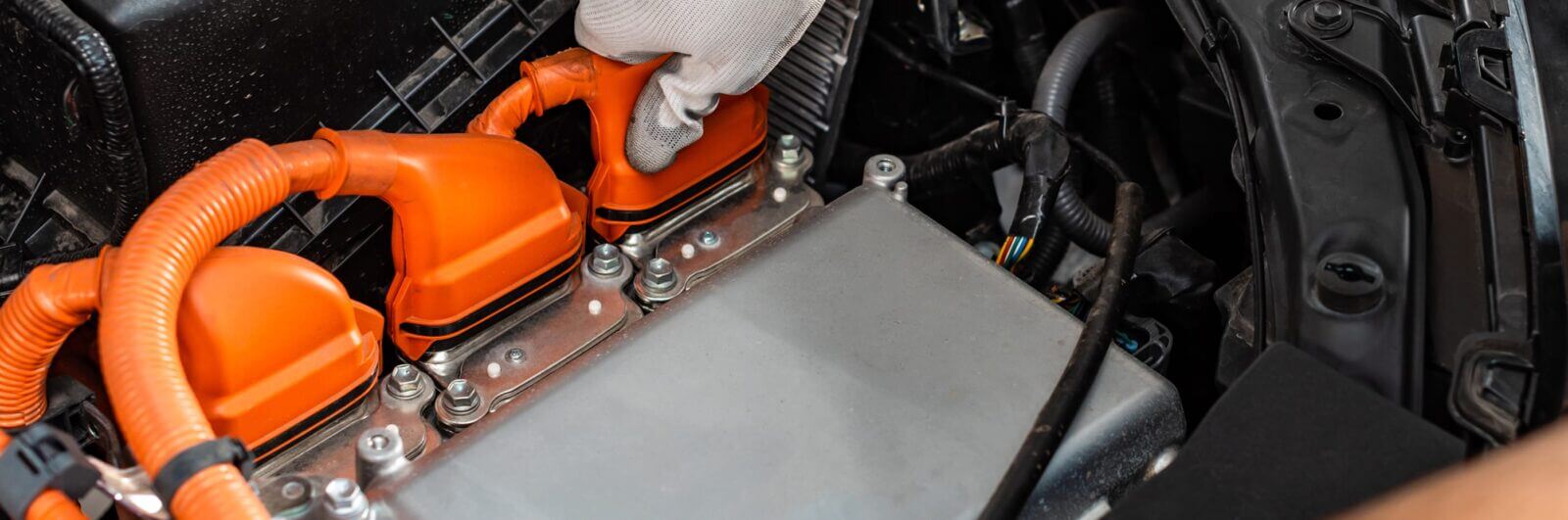 Factory worker plugging in an automotive battery